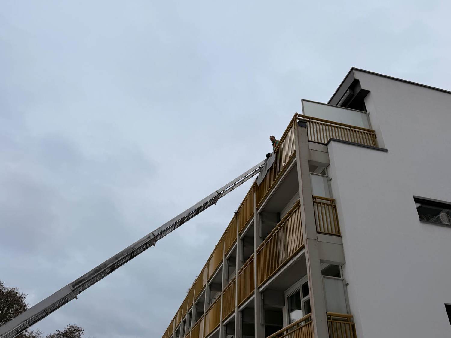 Ladderlift tegen een appartementencomplex tijdens de montage
